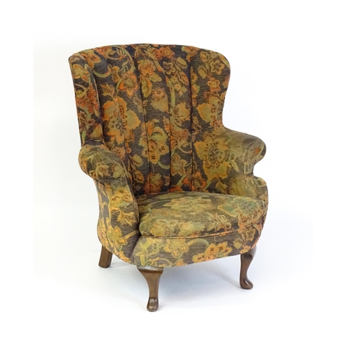 1688 - A mid 20thC barrel back armchair with scrolled arms, sprung seat and raised on cabriole front legs. ... 