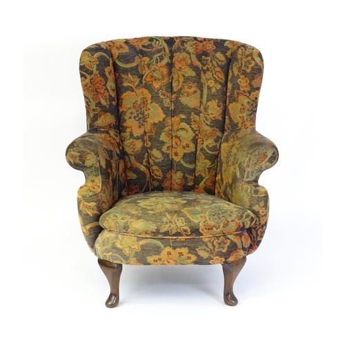 1688 - A mid 20thC barrel back armchair with scrolled arms, sprung seat and raised on cabriole front legs. ... 