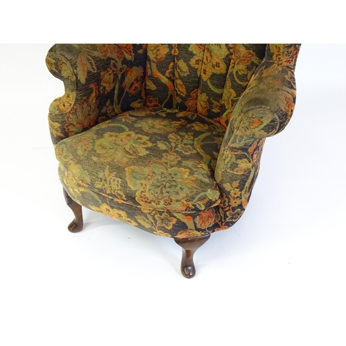 1688 - A mid 20thC barrel back armchair with scrolled arms, sprung seat and raised on cabriole front legs. ... 