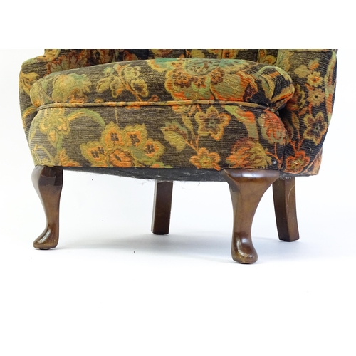 1688 - A mid 20thC barrel back armchair with scrolled arms, sprung seat and raised on cabriole front legs. ... 