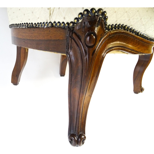 1702 - A late 19thC / early 20thC rosewood nursing chair / salon chair of tub form and raised on carved cab... 