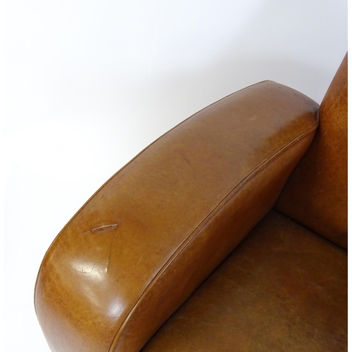 1707 - An early / mid 20thC Art Deco style leather club chair raised on block feet terminating in castors. ... 