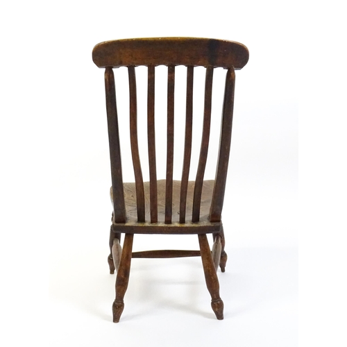 1746 - A 19thC lathe back nursing chair with a shaped elm seat raised on four turned tapering legs united b... 