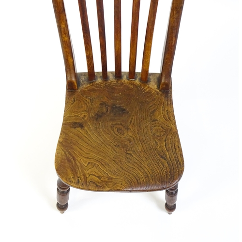 1746 - A 19thC lathe back nursing chair with a shaped elm seat raised on four turned tapering legs united b... 