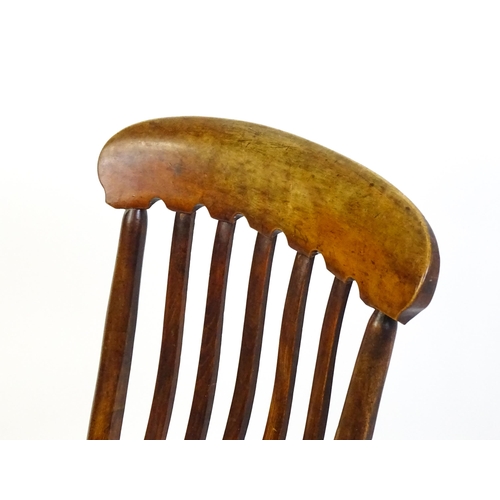 1746 - A 19thC lathe back nursing chair with a shaped elm seat raised on four turned tapering legs united b... 