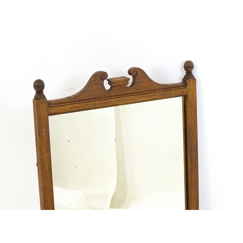 1747 - An early 20thC oak wall mirror / toilet mirror with an architectural swan neck pediment above a hing... 