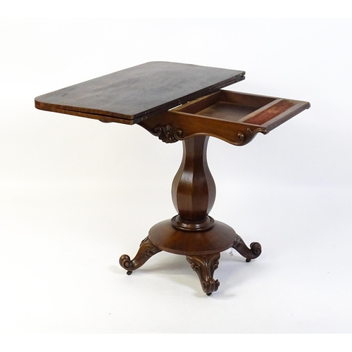 1754 - A 19thC mahogany tea table with a carved floral front panel above a canted and shaped pedestal above... 