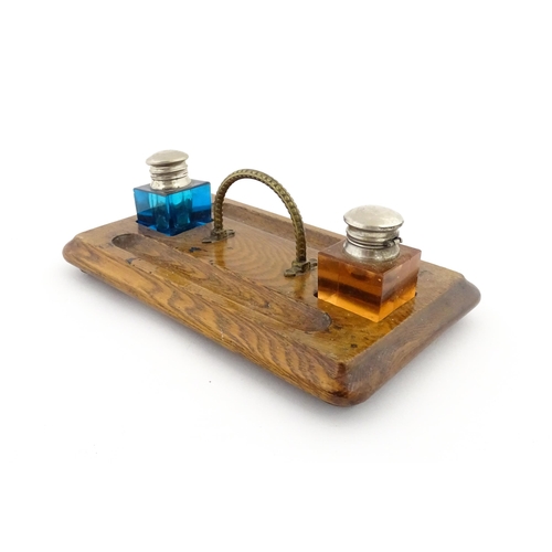 1210A - A Victorian oak standish with two coloured glass inkwells and two pen wells. Together with an onyx s... 