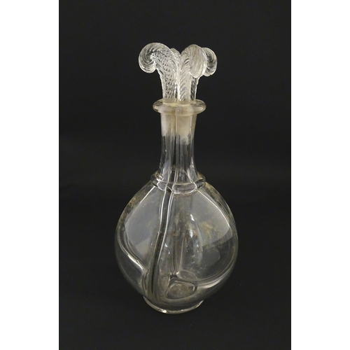 202 - An early 20thC four sectional glass liqueur / liquor decanter having four fleur de lys / feather plu... 