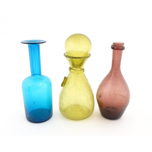 220A - Three items of glassware to include a turquoise glass bottle vase, a purple glass bottle vase and a ... 