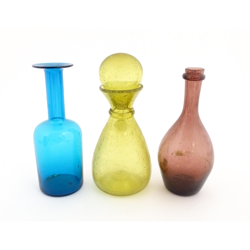 220A - Three items of glassware to include a turquoise glass bottle vase, a purple glass bottle vase and a ... 