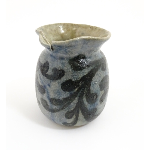 59 - A stoneware jug with blue glaze and foliate decoration. Signed under Martin Bros London. Approx. 4