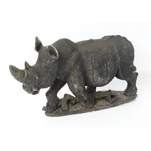 1260 - A large 20thC carved stone model of a rhinoceros / rhino on a naturalistic base. Approx. 15 1/2