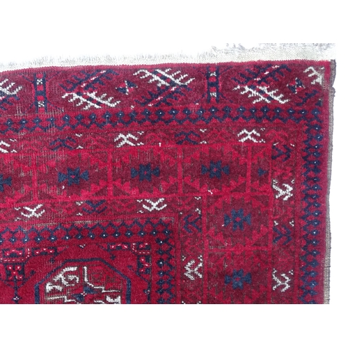 1505 - Carpet / Rug : A red ground rug decorated with repeating geometric motifs. Approx. 75