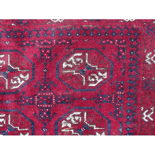 1505 - Carpet / Rug : A red ground rug decorated with repeating geometric motifs. Approx. 75