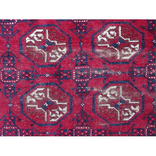 1505 - Carpet / Rug : A red ground rug decorated with repeating geometric motifs. Approx. 75