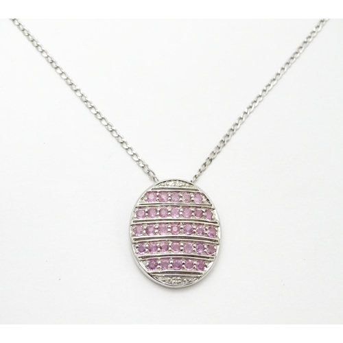 781 - A 9ct white gold pendant of oval form set with diamonds and pink sapphires. On 9ct white gold chain.... 