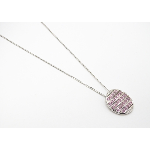 781 - A 9ct white gold pendant of oval form set with diamonds and pink sapphires. On 9ct white gold chain.... 