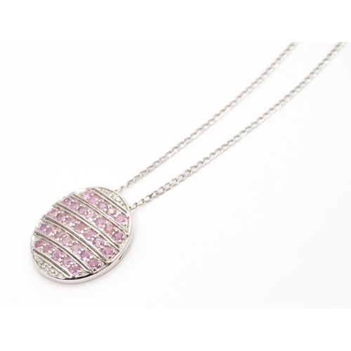 781 - A 9ct white gold pendant of oval form set with diamonds and pink sapphires. On 9ct white gold chain.... 