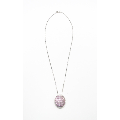 781 - A 9ct white gold pendant of oval form set with diamonds and pink sapphires. On 9ct white gold chain.... 