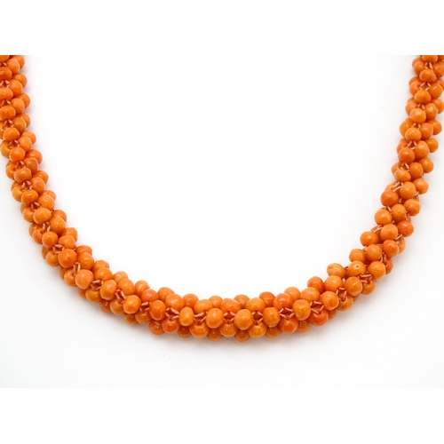 783 - A coral bead necklace. Together with a pair of 9ct gold stud earrings set with coral beads. Necklace... 