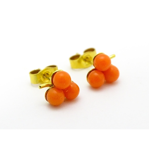 783 - A coral bead necklace. Together with a pair of 9ct gold stud earrings set with coral beads. Necklace... 