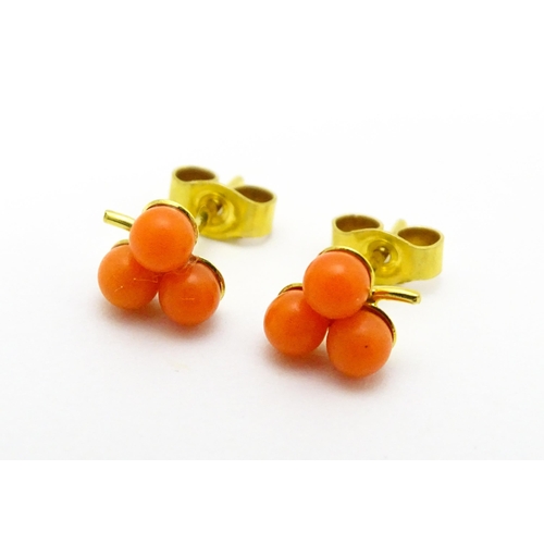 783 - A coral bead necklace. Together with a pair of 9ct gold stud earrings set with coral beads. Necklace... 