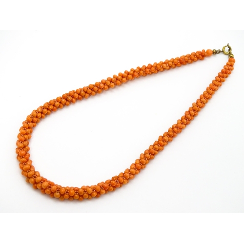 783 - A coral bead necklace. Together with a pair of 9ct gold stud earrings set with coral beads. Necklace... 