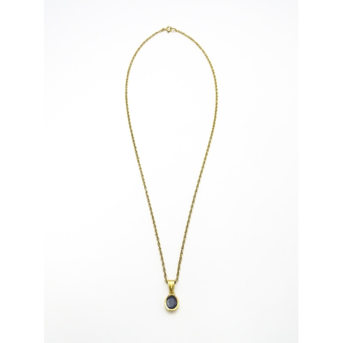 787 - A yellow metal pendant set with central sapphire on a 9ct gold chain. Pendant approx. 1 3/4