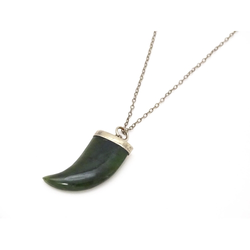 790 - A jade green coloured hardstone pendant with white metal mounts and chain. Pendant approx. 1 3/4