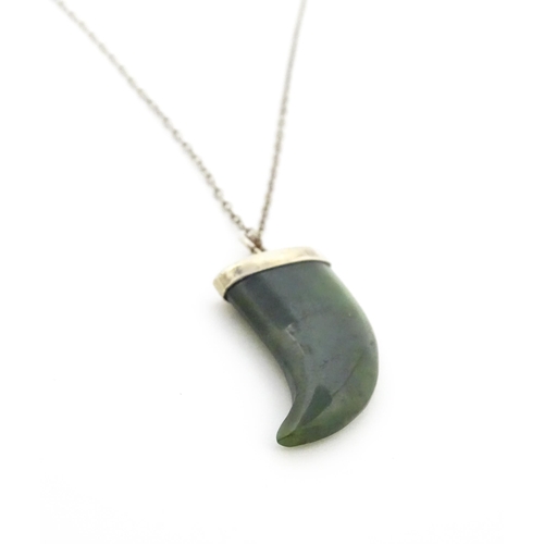 790 - A jade green coloured hardstone pendant with white metal mounts and chain. Pendant approx. 1 3/4