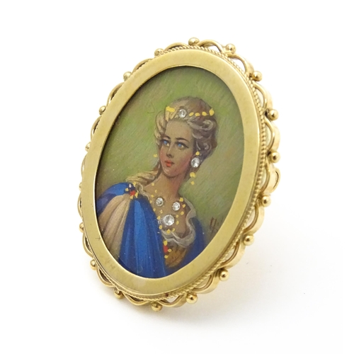 793 - A 9ct gold pendant / brooch with hand painted portrait miniature to centre set with diamonds and sig... 