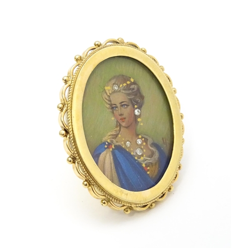 793 - A 9ct gold pendant / brooch with hand painted portrait miniature to centre set with diamonds and sig... 