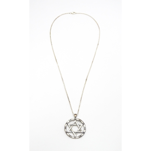 795 - A silver pendant with Star of David detail, on silver chain. Pendant approx. 1 1/4