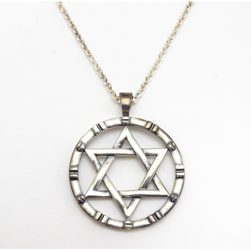 795 - A silver pendant with Star of David detail, on silver chain. Pendant approx. 1 1/4