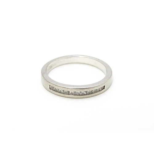 797 - A platinum ring set with 11 diamonds in a linear setting. Ring size approx. K 1/2