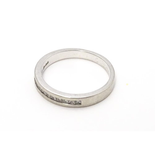 797 - A platinum ring set with 11 diamonds in a linear setting. Ring size approx. K 1/2