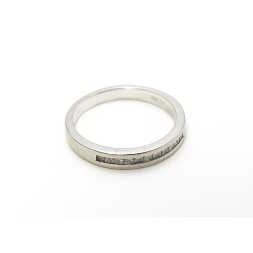 797 - A platinum ring set with 11 diamonds in a linear setting. Ring size approx. K 1/2