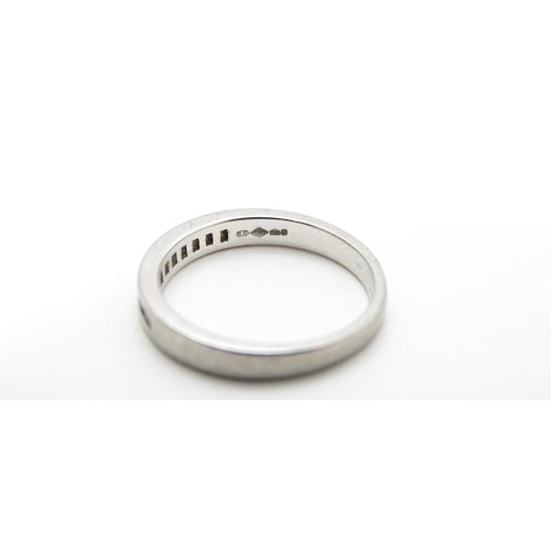 797 - A platinum ring set with 11 diamonds in a linear setting. Ring size approx. K 1/2