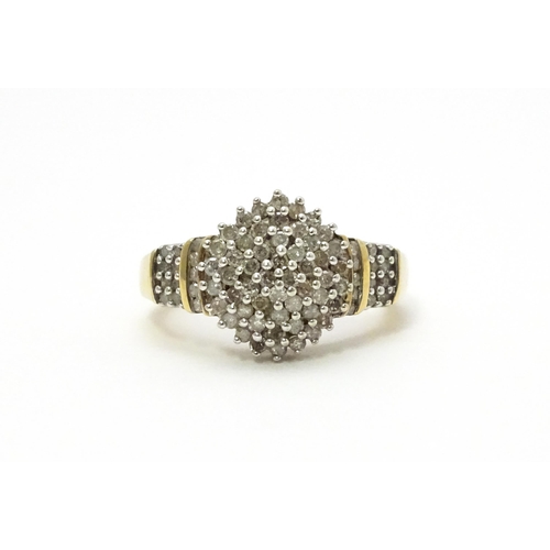 798 - A 9ct gold cocktail ring set with a central cluster of diamonds flanked by further diamonds to shoul... 