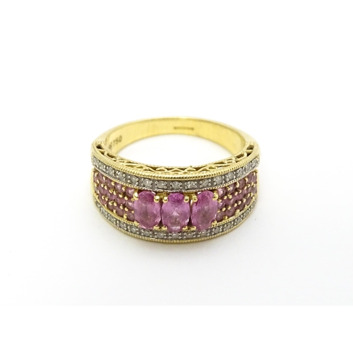 803 - An 18ct gold ring set with pink sapphires and diamonds. Ring size approx. L 1/2