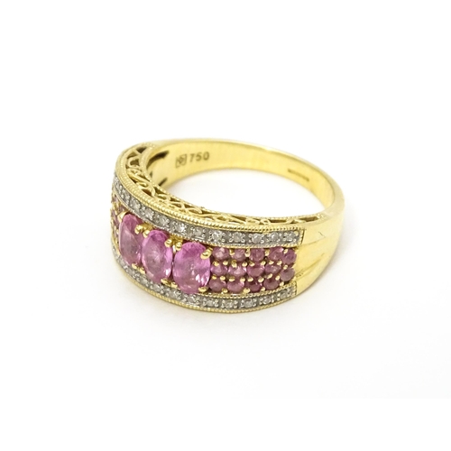 803 - An 18ct gold ring set with pink sapphires and diamonds. Ring size approx. L 1/2