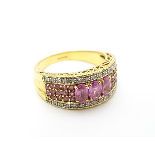 803 - An 18ct gold ring set with pink sapphires and diamonds. Ring size approx. L 1/2