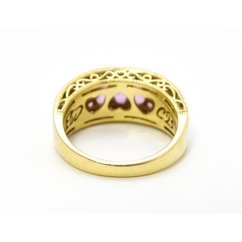 803 - An 18ct gold ring set with pink sapphires and diamonds. Ring size approx. L 1/2