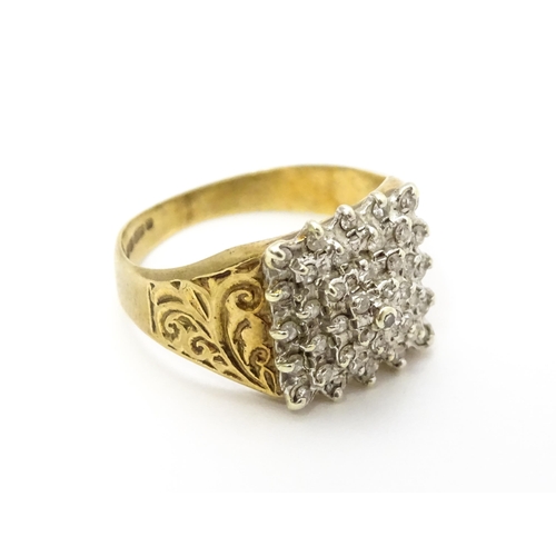 806 - A 9ct gold ring set with a profusion of diamonds in a square setting. Ring size approx. K