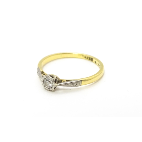 807 - An 18ct gold ring with platinum set diamond solitaire. Ring size approx. M