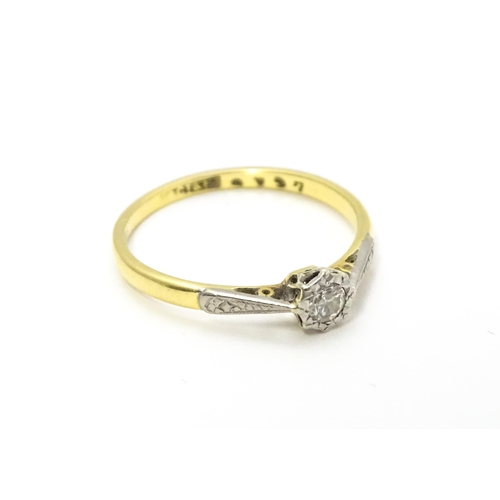 807 - An 18ct gold ring with platinum set diamond solitaire. Ring size approx. M