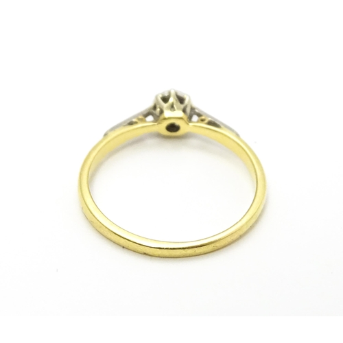 807 - An 18ct gold ring with platinum set diamond solitaire. Ring size approx. M