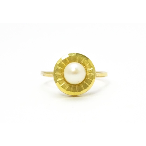 812 - A Continental 9ct gold ring set with central pearl. Ring size approx. L 1/2