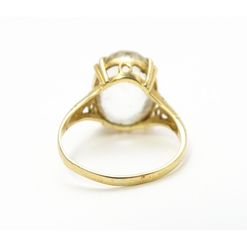 814 - A 9ct gold cocktail ring set with central white stone. Ring size approx. I 1/2